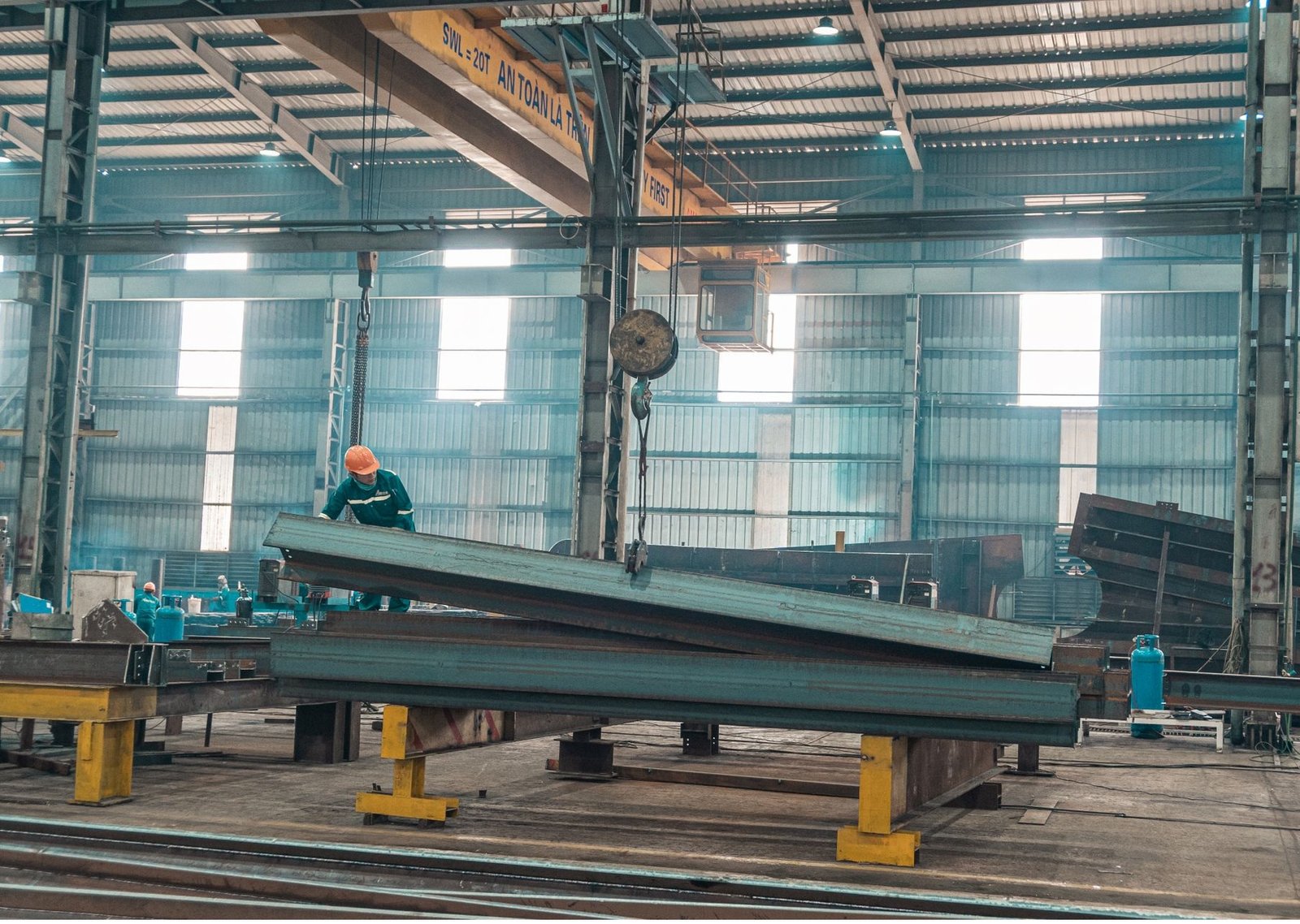 Structural steelwork being handled in a fabrication workshop